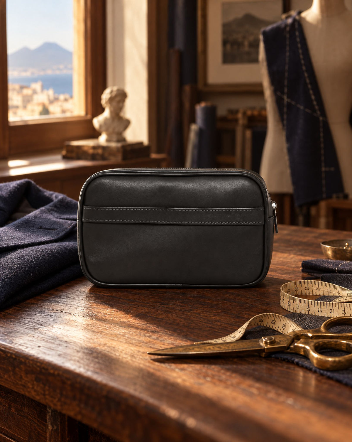 Clutch de piel negra Scarano Napoli sobre una mesa de sastre